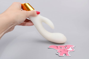 Svietiaci silikónový vibrátor s výbežkom na klitoris Lumisphere Bunny (19,5 cm), v ruke